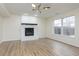 Spacious living room with a cozy brick fireplace, wood-look floors, and natural light at 5869 Jamestown Square Ln, Indianapolis, IN 46234