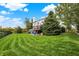 Expansive backyard featuring a lush lawn, mature trees, and a cozy deck with outdoor seating at 6110 Tanana Dr, Carmel, IN 46033