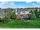 Spacious backyard features a well-maintained lawn, a wooden deck with outdoor seating, and mature trees at 6110 Tanana Dr, Carmel, IN 46033