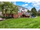 Backyard with a well-maintained lawn, landscaping, brick accents, and a raised deck area at 6110 Tanana Dr, Carmel, IN 46033