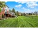 Well-manicured backyard with a spacious lawn, mature trees, and a deck, perfect for outdoor enjoyment at 6110 Tanana Dr, Carmel, IN 46033