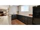 Basement wet bar with granite countertops, dark cabinets, and wood flooring at 6110 Tanana Dr, Carmel, IN 46033
