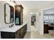 Bathroom featuring dual sinks, dark wood cabinets, and access to a large closet at 6110 Tanana Dr, Carmel, IN 46033
