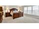 Spacious bedroom with a large window, neutral carpet and sophisticated wood furniture at 6110 Tanana Dr, Carmel, IN 46033