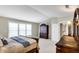 Well-lit primary bedroom with neutral carpeting, large window and lots of dark wood furnishings at 6110 Tanana Dr, Carmel, IN 46033