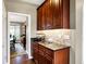 Butler's pantry featuring sleek granite countertops and dark wood cabinetry for ample storage at 6110 Tanana Dr, Carmel, IN 46033