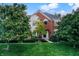 Charming two-story brick home with manicured lawn, mature trees, and classic architectural details at 6110 Tanana Dr, Carmel, IN 46033