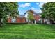 Beautiful brick home featuring lush green lawn, mature landscaping, and inviting front entrance at 6110 Tanana Dr, Carmel, IN 46033