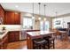 Well-lit kitchen boasts a granite island, stainless steel appliances, and warm wood flooring at 6110 Tanana Dr, Carmel, IN 46033