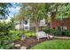 Close-up of professionally landscaped yard with a bird feeder, bench, and colorful flowers at 6110 Tanana Dr, Carmel, IN 46033