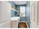 Functional laundry room with modern washer and dryer units, shelving, and ample natural light at 6110 Tanana Dr, Carmel, IN 46033