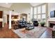 Open concept living room features large windows, hardwood floors, and a cozy fireplace at 6110 Tanana Dr, Carmel, IN 46033