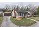 Quaint single-story home featuring a detached garage, well-kept lawn and mature trees at 631 E 86Th St, Indianapolis, IN 46240