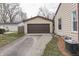 Detached two-car garage with brown doors and neutral siding, located next to the main house at 631 E 86Th St, Indianapolis, IN 46240