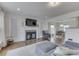 Bright living room with a fireplace, mounted TV, and a comfortable gray ottoman at 631 E 86Th St, Indianapolis, IN 46240