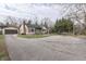 Home with detached garage and wide driveway, situated on a street with established trees at 631 E 86Th St, Indianapolis, IN 46240