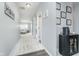 Hallway featuring hardwood flooring, neutral paint, and decor. Leads to a living space with lots of natural light at 726 Jefferson Park Dr, Pittsboro, IN 46167