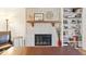 Stylish fireplace featuring a brick surround, wood mantel, adjacent bookshelf and comfortable furniture at 788 S Harbour Dr, Noblesville, IN 46062