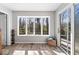 Sunroom with large bay window overlooking mature trees and a sliding glass door to an outdoor deck at 788 S Harbour Dr, Noblesville, IN 46062