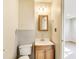 This bathroom features a light wood vanity, mirror, lights and toilet at 7906 E 21St St, Indianapolis, IN 46219
