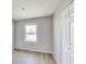 This bedroom features light grey walls, light wood-look flooring, a window and a closet at 7906 E 21St St, Indianapolis, IN 46219