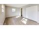 This bedroom features light grey walls, light wood-look flooring, a window and a closet at 7906 E 21St St, Indianapolis, IN 46219