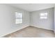 This bedroom features light grey walls, light wood-look flooring and two windows at 7906 E 21St St, Indianapolis, IN 46219