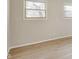 Bright living room features light grey walls and light wood-look flooring with two windows at 7906 E 21St St, Indianapolis, IN 46219