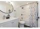 Well-lit bathroom featuring modern fixtures, round mirror and shower with curtain at 8228 Morel Dr, Indianapolis, IN 46256