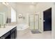 A bright bathroom featuring a white tub, gold shower, and navy vanity with gold hardware at 8228 Morel Dr, Indianapolis, IN 46256