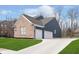 Charming two-story home with brick and vinyl siding, a well-manicured lawn, and a three-car garage at 8228 Morel Dr, Indianapolis, IN 46256