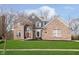 Beautiful brick home featuring a manicured lawn and elegant architectural details at 8228 Morel Dr, Indianapolis, IN 46256