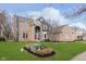 Beautiful brick home with a manicured lawn, mature trees, and an arched entryway, perfect for Gathering living at 8228 Morel Dr, Indianapolis, IN 46256