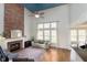 Open living room with brick fireplace, hardwood floors, and large windows providing natural light at 8228 Morel Dr, Indianapolis, IN 46256