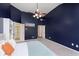Modern bedroom with blue accent wall, large bed, ceiling fan, and ensuite bathroom with glass door at 8228 Morel Dr, Indianapolis, IN 46256