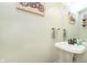 Compact powder room featuring a pedestal sink, vintage mirror, and decorative artwork, perfect for guests at 8228 Morel Dr, Indianapolis, IN 46256