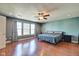 Bright main bedroom with wood floors, large window, ceiling fan, and ensuite bathroom at 8316 S Swimming Hole Ln, Pendleton, IN 46064