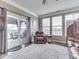 Bright living room featuring a cozy leather chair, sliding glass doors to patio, and three large windows at 834 Bristle Lake Dr, Brownsburg, IN 46112