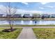 Scenic view of a paved walking path bordering a tranquil pond lined with residential homes at 8610 Fawn Way, McCordsville, IN 46055