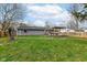 A spacious backyard with a well-maintained lawn, a deck with a pergola, and a fenced perimeter at 8829 Depot Dr, Indianapolis, IN 46217