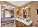 The bathroom boasts a vanity with mirror and adjoins the Primary bedroom with a light wood floor at 9255 W 30Th St, Indianapolis, IN 46234