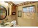 Decorated bathroom showcasing a framed mirror, window treatment, and warm tones at 9255 W 30Th St, Indianapolis, IN 46234