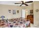 Comfortable bedroom with a ceiling fan, wood floors, decorative accents, and an adjacent open door at 9255 W 30Th St, Indianapolis, IN 46234