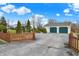 Long asphalt driveway leading to a two-car garage, lined with neatly trimmed shrubs and a partial picket fence at 9255 W 30Th St, Indianapolis, IN 46234