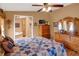 Comfortable main bedroom featuring a ceiling fan, dresser, and ensuite bathroom with a unique quilt design at 9255 W 30Th St, Indianapolis, IN 46234