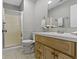 Bright bathroom with a wood vanity, modern sink, mirror, and a glass-enclosed shower at 9464 Fordham St, Indianapolis, IN 46268