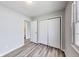 This bedroom features neutral walls, modern gray vinyl floors, and a closet for optimal storage at 9525 Meadowlark Dr, Indianapolis, IN 46235