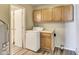 This laundry room features wooden cabinets, gray walls, and modern gray vinyl floors throughout at 9525 Meadowlark Dr, Indianapolis, IN 46235