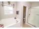 Clean bathroom with a tub, a shower, and a window that provides light at 9752 Brook Wood Dr, McCordsville, IN 46055