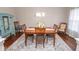 Traditional dining room featuring hardwood floors, an area rug, and a wooden table with seating for six at 9752 Brook Wood Dr, McCordsville, IN 46055